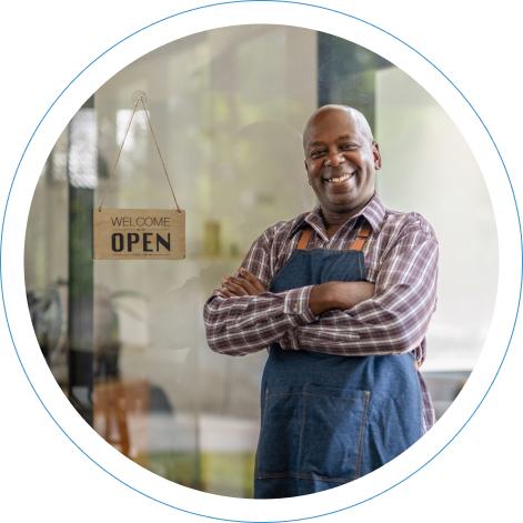 Business owner standing next to Open for Business sign